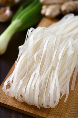 Çiğ pirinç unu şehriye ahşap masa, doğal ışık (seçici odak, odak ortasında erişte ile fotoğraflandı üzerinde)