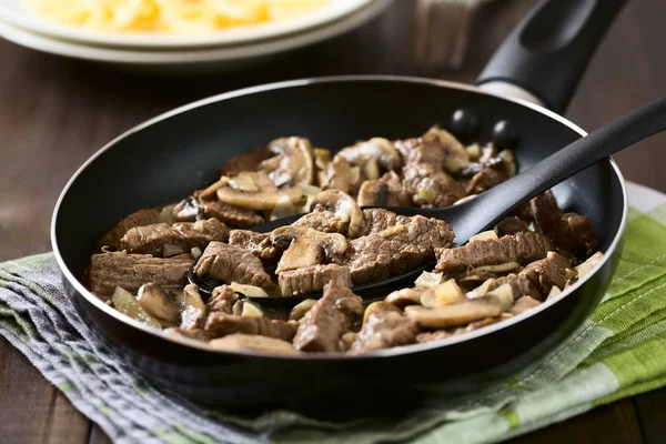 프라이팬에 쇠고기 스트로 쇠고기 버섯과 양파의 조각으로 만들어진 선택적 숟가락에 — 스톡 사진