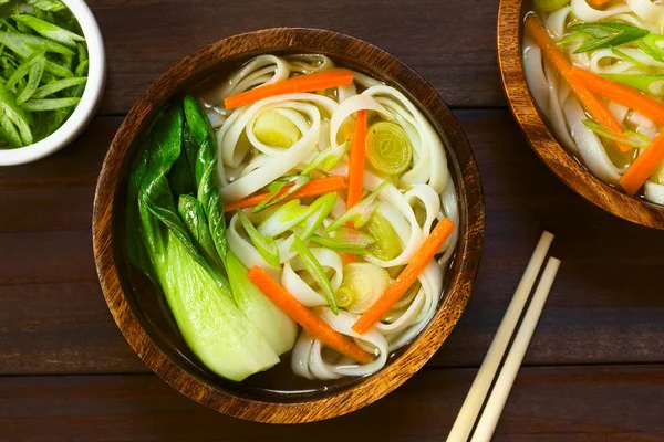 ベジタリアン アジア麺スープ チンゲン菜 ニンジン 撮影自然光 選択と集中 スープの上にフォーカスとダークウッドのオーバーヘッド — ストック写真