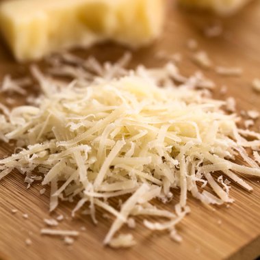 Ahşap masa, doğal ışık (seçici odak, odak ortasında görüntü fotoğrafı üzerinde taze rendelenmiş parmesan benzeri sert peynir)