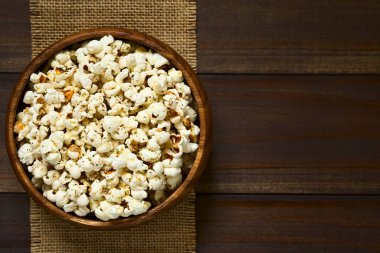 Peynir, sarımsak ve ek yükü üzerinde koyu renkli ahşap doğal ışık (seçici odak, odak üstünde patlamış mısır ile fotoğraflandı kurutulmuş kekik ahşap kase, ev yapımı taze kokulu patlamış mısır)