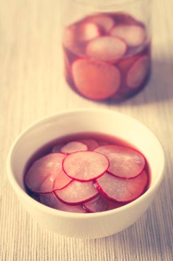 Şeker ve tuz, kırmızı şarap sirkesi turşusu ince dilim kesilmiş taze turp fotoğrafı doğal ışık (seçici odak, odak üstünde belgili tanımlık tepe turp dilim ön) ile (dijital olarak değiştirilmiş: tonlu görüntü)