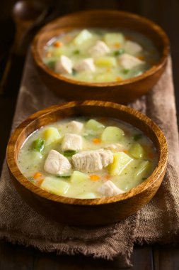 Yeşil biber ve koyu renk ahşap doğal ışık (seçici odak, odak ilk çorba ortasında ile üstünde fotoğraflandı havuç ahşap kase, tavuk ve patates çorbası çorbası)