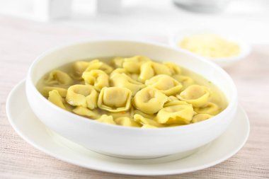 Brodo (suyu) çorbası, doğal ışık (seçici odak, odak görüntünün ortasında ile fotoğraflandı geleneksel İtalyan Tortellini)