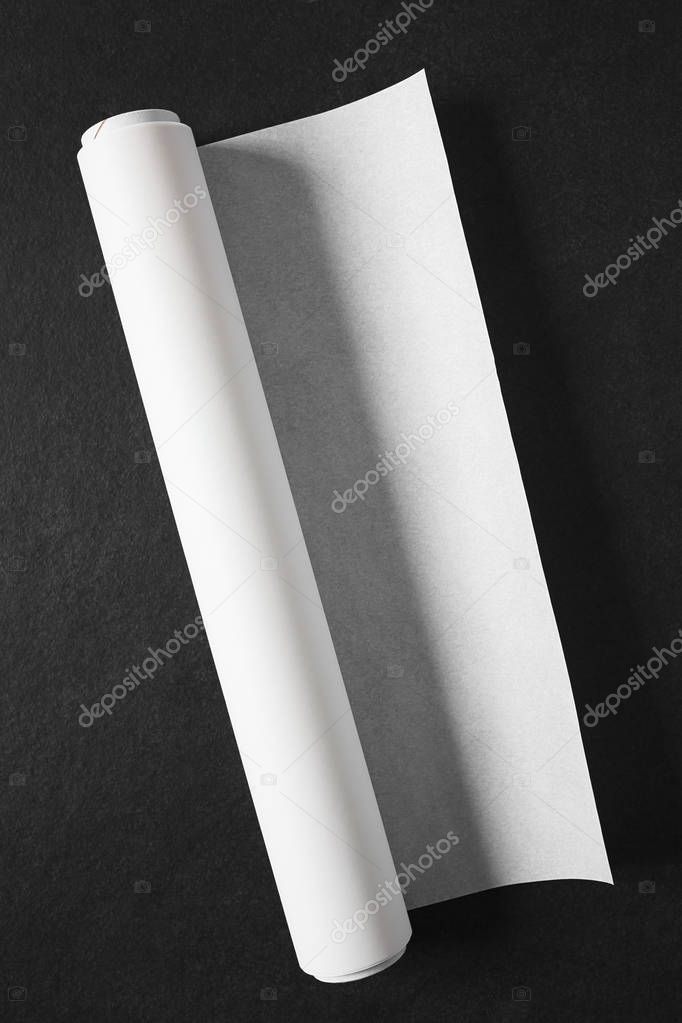 Roll of white baking paper photographed overhead on slate with natural light