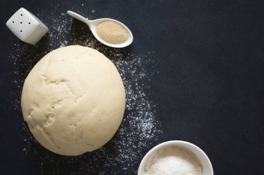 Artış ya da müspet Maya hamur ekmek veya unlu bir kayrak yüzeyi maddeler tarafında, pizza için ek yükü doğal ışık (seçici odak, odak üstünde hamur ile fotoğraflandı.) 