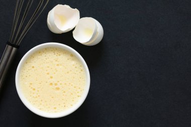 Kasede çırpma teli ve yumurta kabukları tarafında, ek yükü barut doğal ışık ile fotoğrafı ile cirpilmis bütün yumurta (akı ve sarısı birlikte)