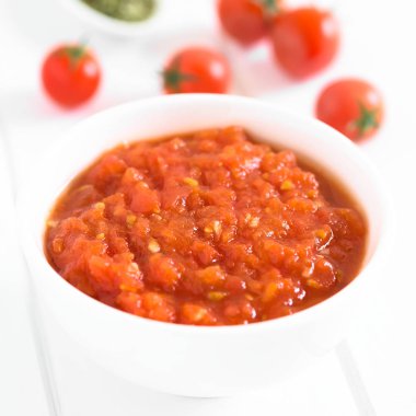 Ev yapımı geleneksel İtalyan marinara veya pomodoro taze domates, sarımsak, kurutulmuş kekik ve tuz, domates sosu arkadaki malzemelerle kase hizmet, doğal ışık (seçici odak ile beyaz tahta üzerinde fotoğrafı)