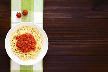 Geleneksel İtalyan spagetti alla Marinara (domates soslu spagetti) kase, fotoğrafı ek yükü doğal ışık ile karanlık ahşap üzerine