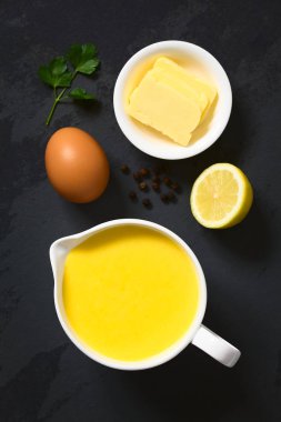 Ek yükü barut doğal ışık ile fotoğraflandı yan bir sos teknede malzemelerle (yumurta, tereyağı, limon, karabiber) Hollandaise sosu, Fransız mutfağının temel bir sos servis 