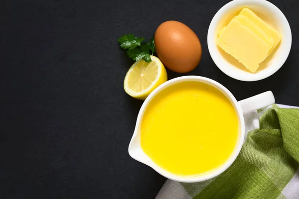 自然光とスレートのオーバーヘッド撮影側材 バター レモン ソース ボートにて オランデーズ ソース フランス料理の基本的なソース — ストック写真
