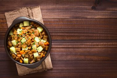 Geleneksel Şili Estofado ya da Guiso de Cochayuyo (lat. Durvillaea Antarktika), bir Vejetaryen Güveç boğa kelp, patates, havuç ve soğan, maydanoz rustik kasede servis, ek yükü doğal ışık ile karanlık ahşap üzerine fotoğrafı