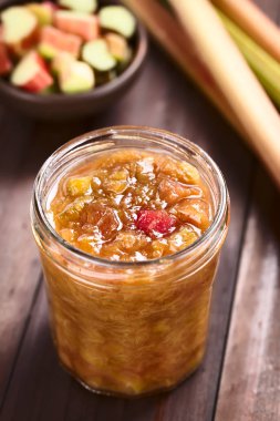 Ev yapımı ravent reçeli kavanozda, arkasında çiğ ravent var. (Seçici Odak, görüntünün ortasına odaklan.))