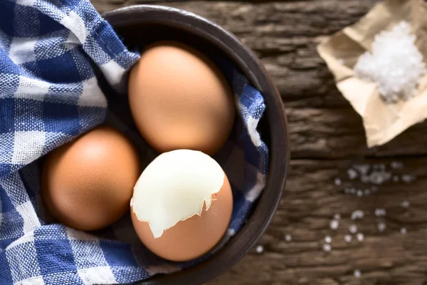 소금이 그릇에 달걀을 요리하여 사진을 찍었다 조심성 껍질을 달걀의 꼭대기에 — 스톡 사진