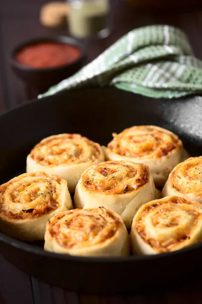 Homemade pizza rolls or pinwheels filled with ham, onion, tomato sauce and cheese, photographed with natural light (Selective Focus, Focus on the middle of the middle roll)