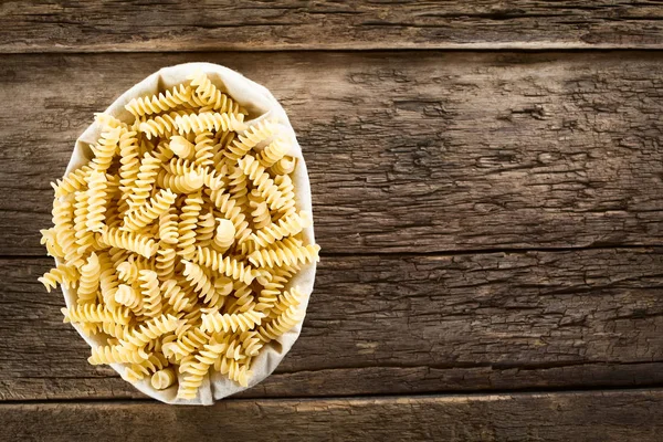 Surové Rotini Nebo Fusilli Těstoviny Textilním Sáčku Fotografované Rustikálním Dřevě — Stock fotografie