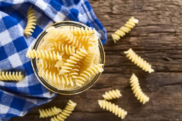 Massa Crua Rotini Fusilli Frasco Vidro Fotografada Cima Madeira Rústica — Fotografia de Stock