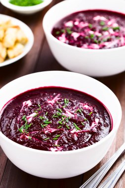 Kaselerde taze ev yapımı pancar kremaçorbası, krema ve frenk soğanı ile süslenmiş (Seçici Odak, Odak ilk çorba içine üçte bir)