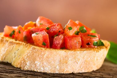 Taze ev yapımı domates ve fesleğenli bruschetta geleneksel İtalyan antipasto (Seçici Odak, ilk domates parçalarına odaklan)
