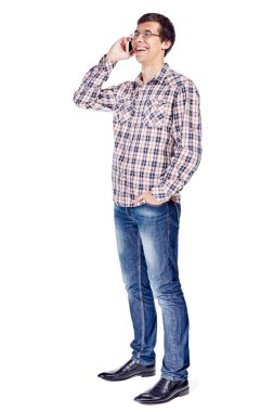 Tam vücut yarısı cep telefonu metal çerçeve gözlük, kareli gömlek, kot ve beyaz arka plan üzerinde izole siyah ayakkabı giyen konuşurken gülümseyen genç adam portresi görünümü Kapat