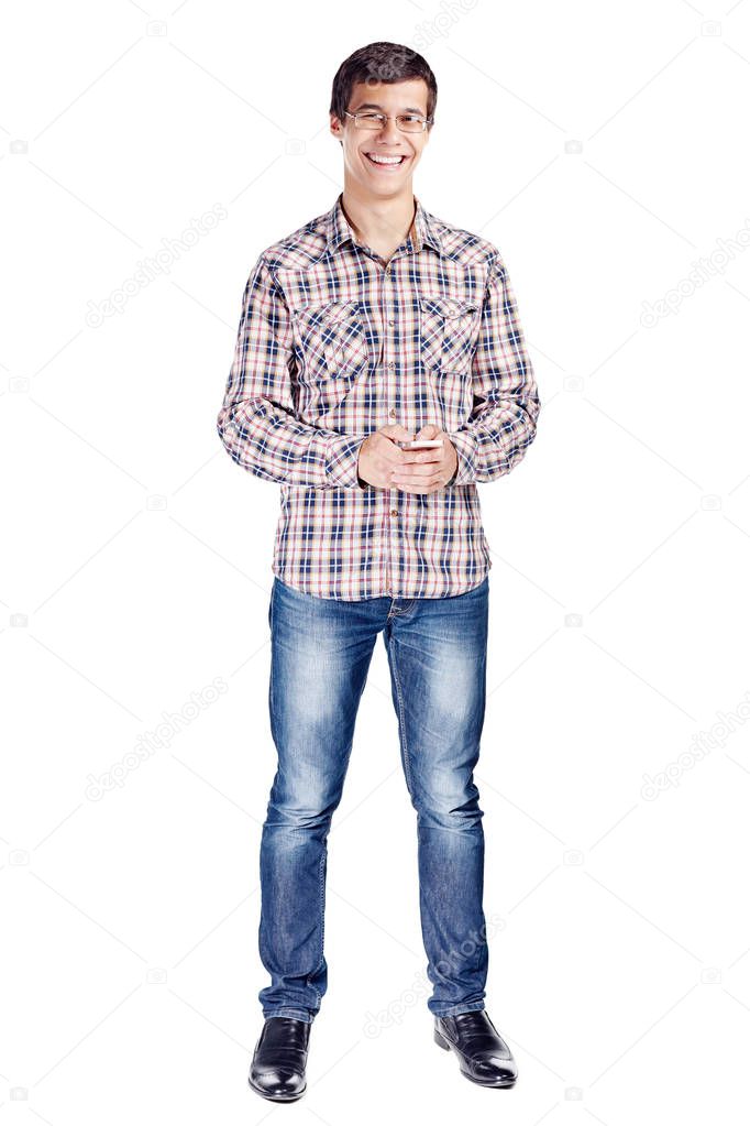 Full body portrait of smiling young man with mobile phone in hands, wearing metal frame glasses, checkered shirt, blue jeans and black shoes isolated on white background