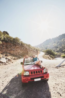 Mutlu güzel kaygısız genç kadın eğleniyor Cabrio 4 x 4 araba dağlarda - yol yolculuk macera konsepti kaporta üzerinde oturan