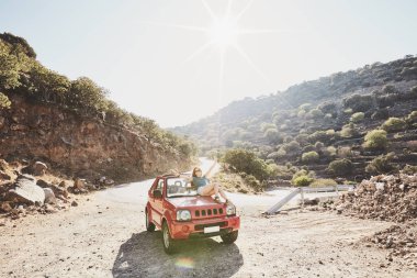 Mutlu güzel kaygısız genç kadın eğleniyor Cabrio 4 x 4 araba dağlarda - yol yolculuk macera konsepti kaporta üzerinde oturan
