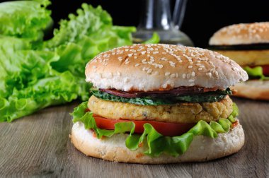 Bu lezzetli glutensiz topuz ile ketçap bulaşmış ve hardal, hassas marul ile altın bir huysuz kıyılmış nohut için kavrulmuş ve taze salatalık dilimleri ile mavi tatlı soğan kıyılmış