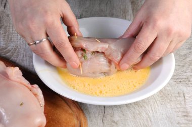 Yemek. Bir kadın eli içinde bir yumurta dolması çiğ tavuk göğsü dips. Adım adım tarifi. Yemekleri pişirme sahne hazırlığı. Serisi.