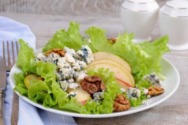 Bir ışık marul salatası armut dilimleri, gorgonzola parçaları ve ceviz ile zeytinyağı ile terbiyeli