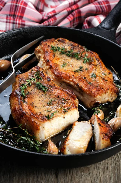 ハーブとフライパンのカットでニンニク油で揚げ豚肉ステーキ — ストック写真