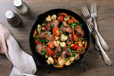 Kızarmış tavuk karaciğer domates, havuç, mantar, bezelye bir tavada sebze garnitür ile