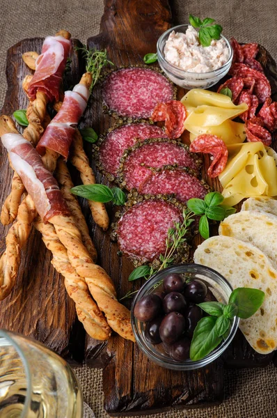 サラミ ソーセージ パン棒 グリッシーニ ラップで前菜スナック料理生ハムとオリーブとチーズが木の表面に貼り付ける — ストック写真