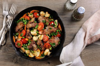 Kızarmış tavuk karaciğer domates, havuç, mantar, bezelye bir tavada sebze garnitür ile