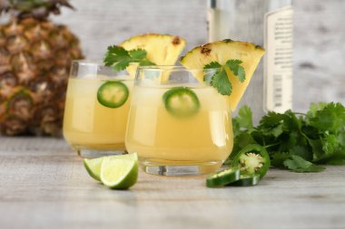 Ananas suyu, jalapeno dilimleri ve kişniş ile soğutulmuş tekila kokteyli.