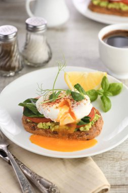 Kahvaltıda. En iyi yumurtalı Benedict tost ekmeği, yanında guacamole ve ıspanak.