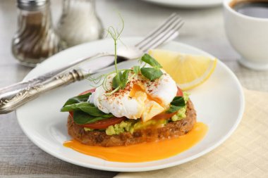  Kahvaltıda. En iyi yumurtalı Benedict tost ekmeği, yanında guacamole ve ıspanak.