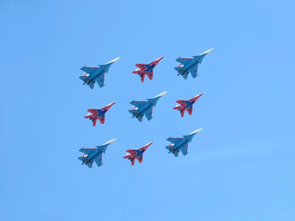 stock image MOSCOW, RUSSIA - MAY 9, 2018: Aerobatic groups Russian Knights and Swifts on MIG-29 and SU-27 fighters  demonstrates Kubinsky Diamond in flight against blue sky on parade flight  on May 9, 2018