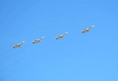 MOSCOW, RUSSIA - May 9, 2018: Group of Russian military tactical front-line bombers SU-24 fast fliying in the blue sky on parade on May 9, 2018 clipart