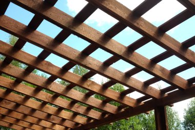 Güneşli yaz gün yan görünüm açık kahverengi ahşap pergola tepesine