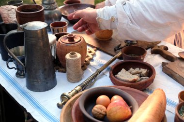 Natürmort antik kırsal taçları ile Fransız ağaç ve metal mutfak eşyaları, vintage ölçekler ve basit rustik gıdalar üzerinde beyaz dokuma masa örtüsü açık havada üstten görünüm