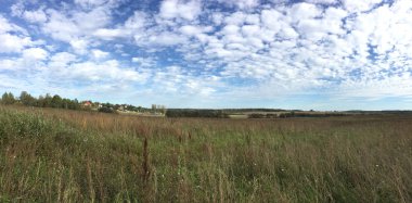 Panoramik kırsal peyzaj alanı ve çok güzel mavi gökyüzü ile yaz günde birçok beyaz bulutlar altında orman ile