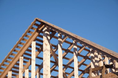 Ahşap karkas ev montaj ubder sürecinin bulutsuz mavi gökyüzü yan görünüm temizleyin. Ahşap ülke ev yapımı