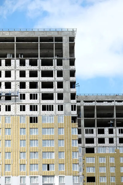 在阳光明媚的日子里 在蓝天上顶层的高层现代公寓楼的施工过程垂直视图 — 图库照片