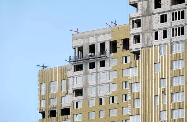 青い上空雲のクローズ アップと新しい近代的な都市住宅のアパートの建物ファサードの絶縁をマウントするプロセス — ストック写真