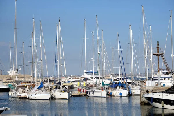 Tight marine yacht parking in calm water on bright summer day with mountains af far