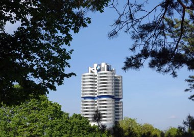 Münih, Almanya-Mayıs 1, 2019: güneşli bir gün ağaç dalları çerçeve içinde Münih BMW Merkez Bina