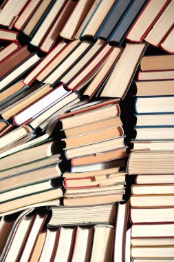Arka plan ön görünümü yakından olarak birçok çeşitli eski kitaplar yığınları yatıyor