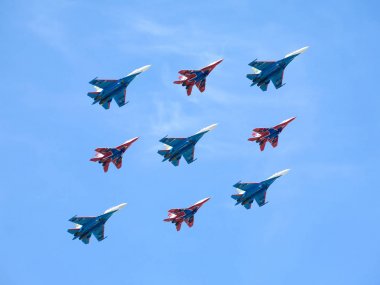 Moskova, Rusya - 9 Mayıs 2015: Mavi gökyüzü karşı geçit uçuş Mig-29 ve Su-27 savaşçıları hafif bulutlu 9 Mayıs 2015 tarihinde Moskova'da Rus Knights ve ebabiller akrobasi grupları