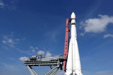 Spaceship on launch pad ready to fly into space vertical photo over blue sky horizontal photo clipart
